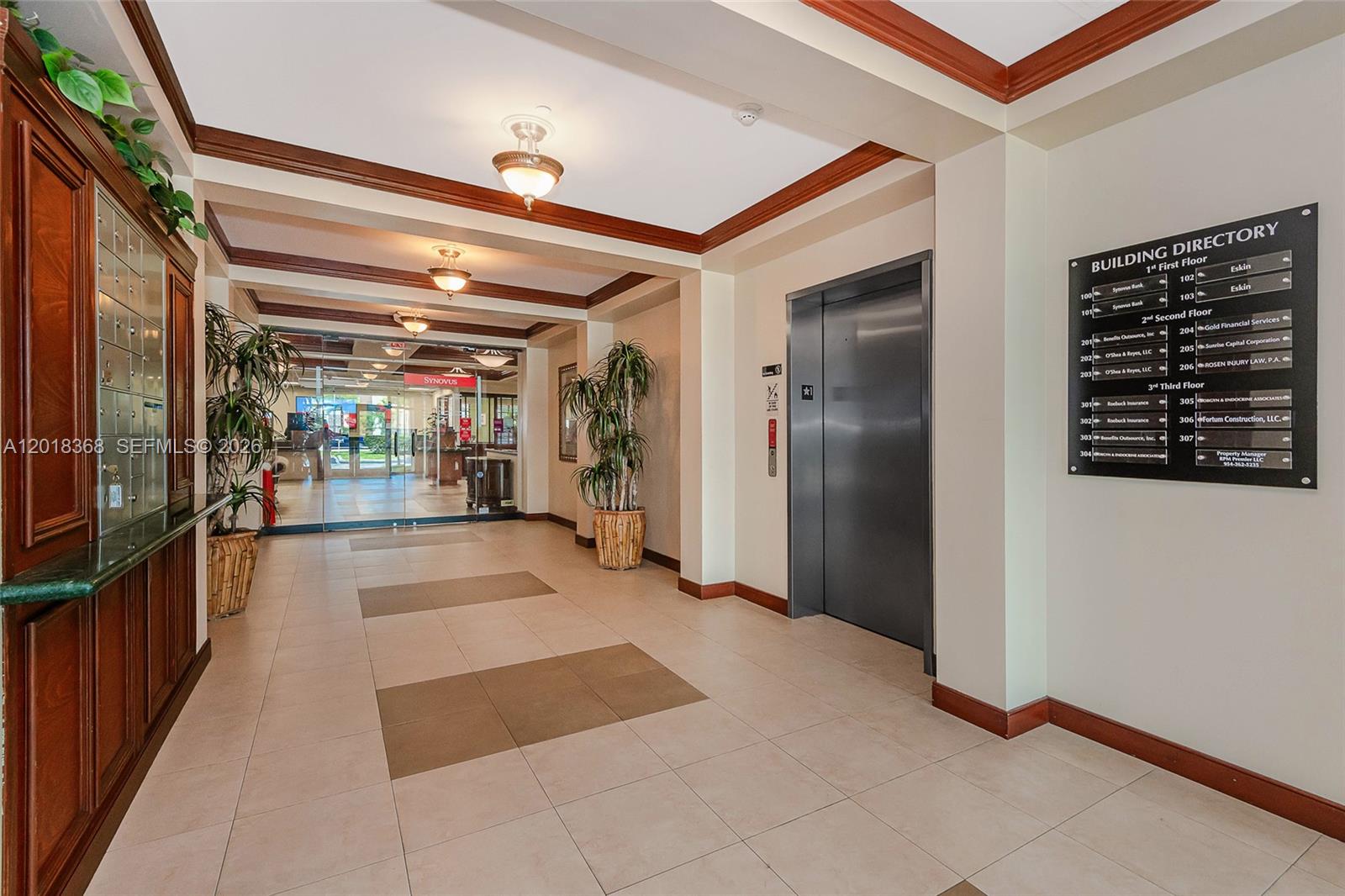 A building lobby features a directory sign, an elevator, tile flooring, and a glass entrance — 5599 S University Dr # 205, Davie FL 33328, DAVIE, FL