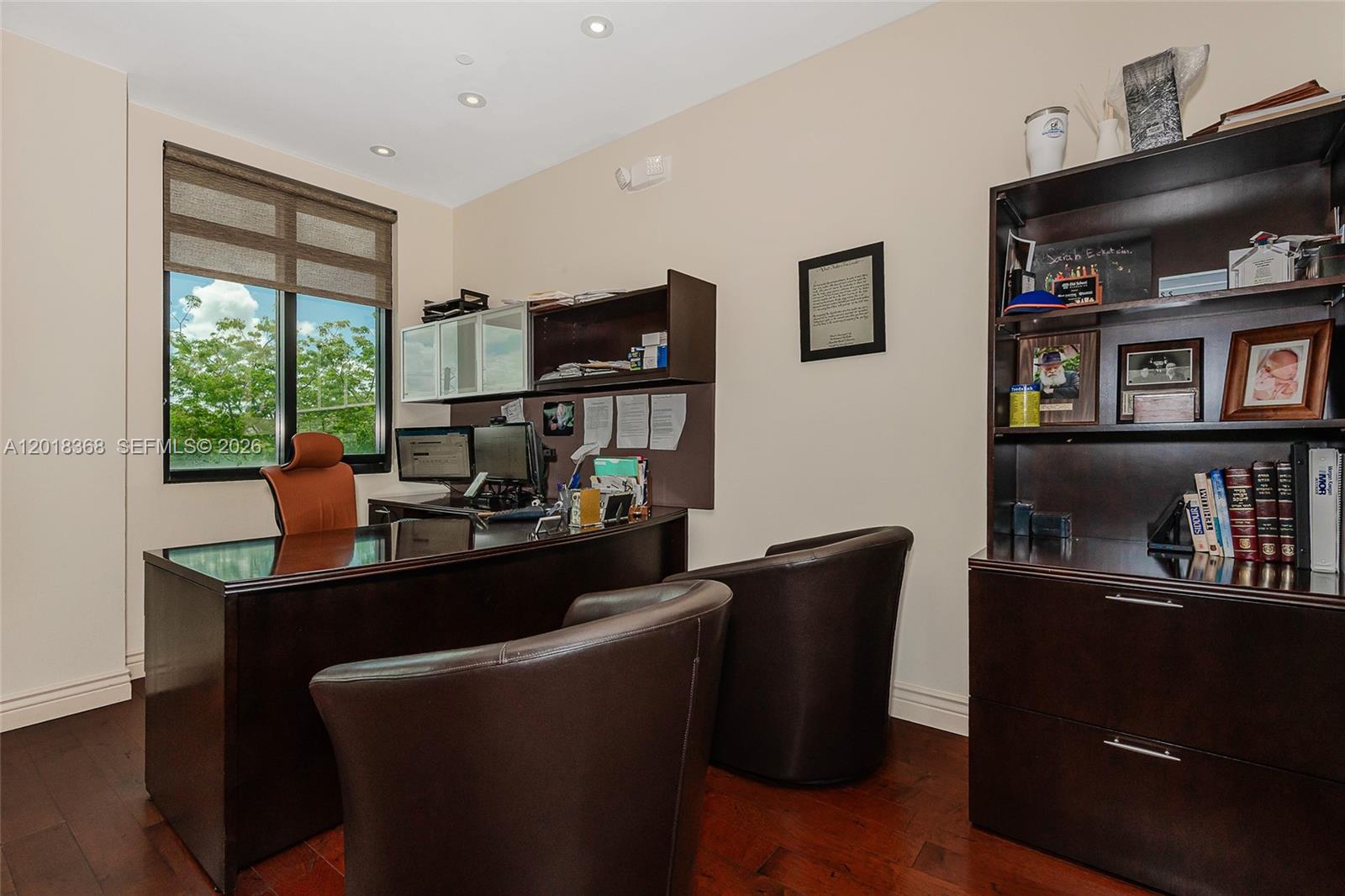 A home office features a dark wood desk, two leather chairs, and a tall bookshelf — 5599 S University Dr # 205, Davie FL 33328, DAVIE, FL