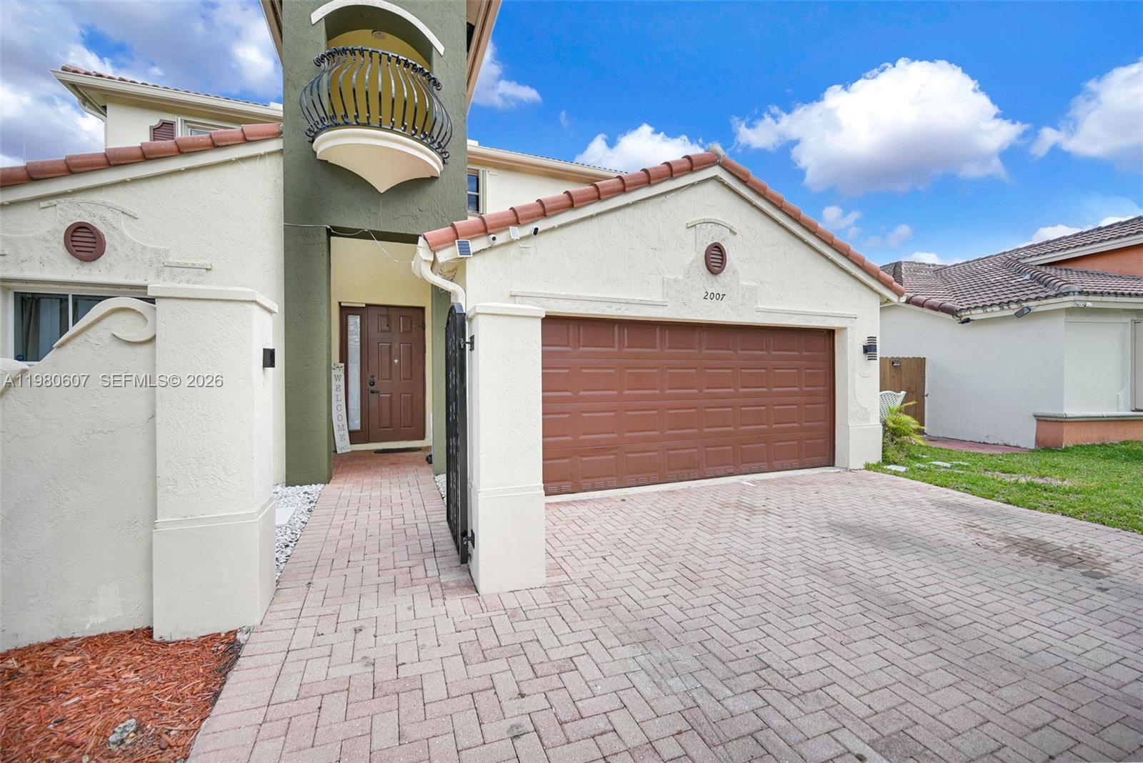 A brown front door with a side window sits at the end of a walkway — 2007 NE 6th Ct, Homestead FL 33033, HOMESTEAD, FL
