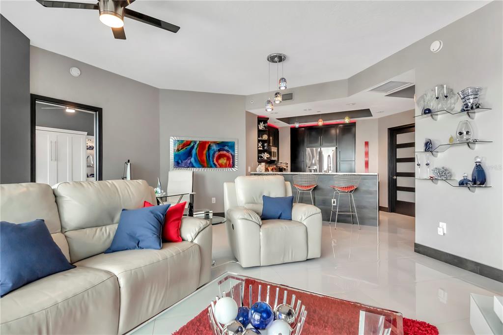 A modern living room features white leather furniture, a glass coffee table, and an open kitchen — 449 S 12TH STREET UNIT 1006, TAMPA, FL