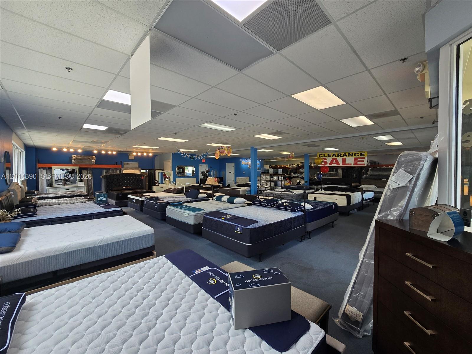 A mattress store showroom features rows of beds, drop ceilings, and a clearance sale sign — 100 N State Road 7 # 102, Margate FL 33063, MARGATE, FL