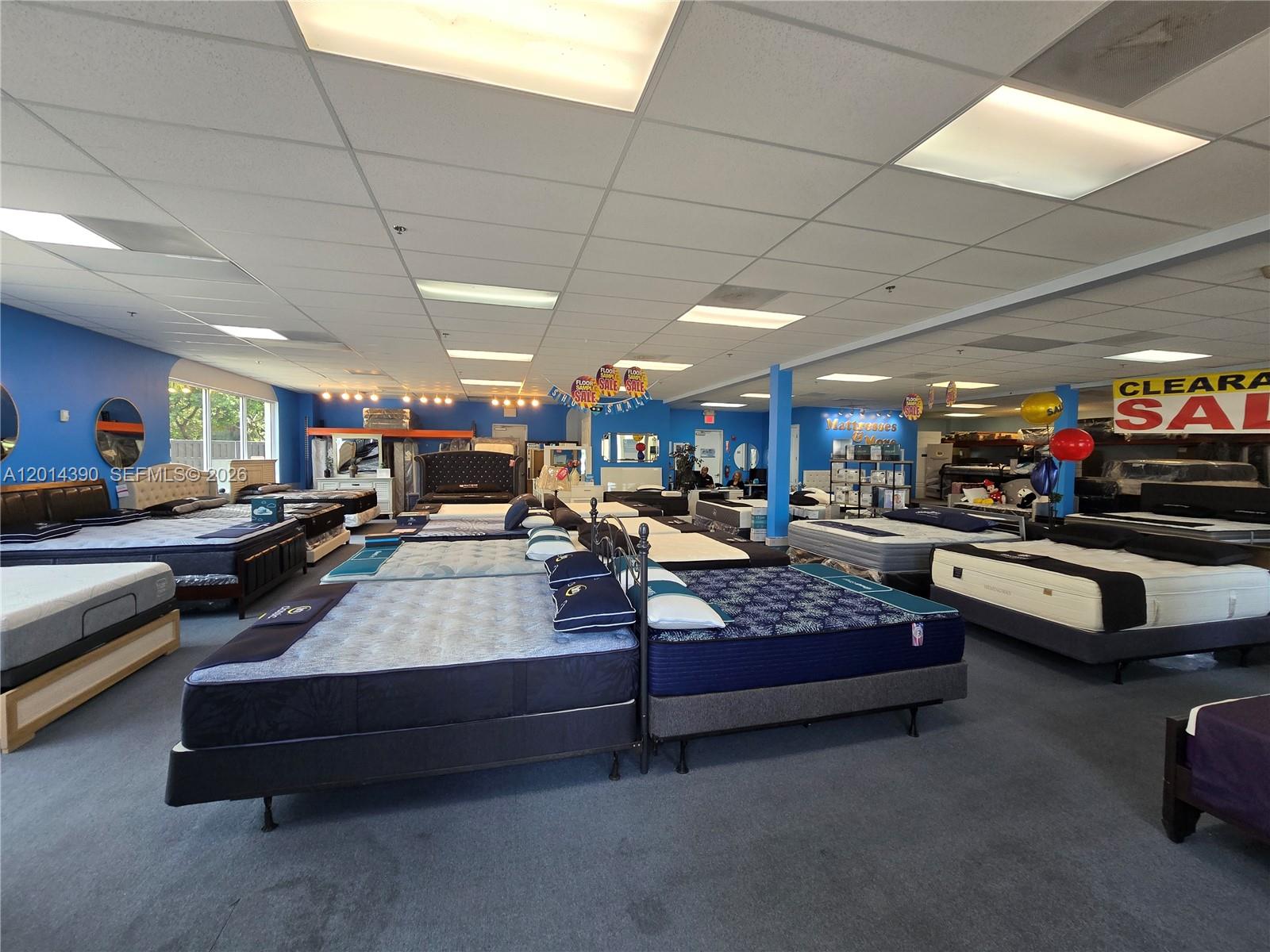 A mattress store showroom features multiple beds displayed on a gray carpeted floor — 100 N State Road 7 # 102, Margate FL 33063, MARGATE, FL