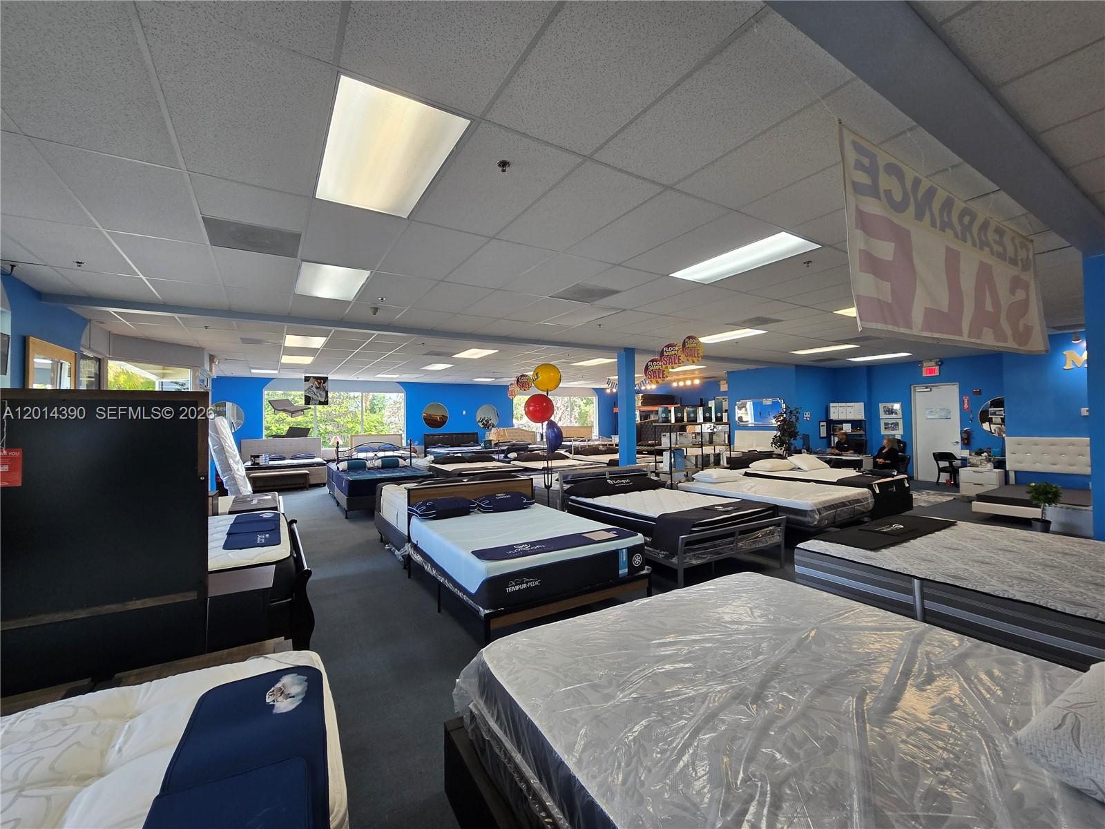 A mattress showroom features rows of beds on display under a drop ceiling with lights — 100 N State Road 7 # 102, Margate FL 33063, MARGATE, FL