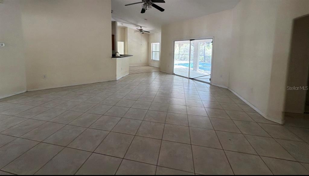 A covered patio overlooks a screened-in swimming pool with a green safety cover — 1365 BLAISDELL STREET, PORT CHARLOTTE, FL