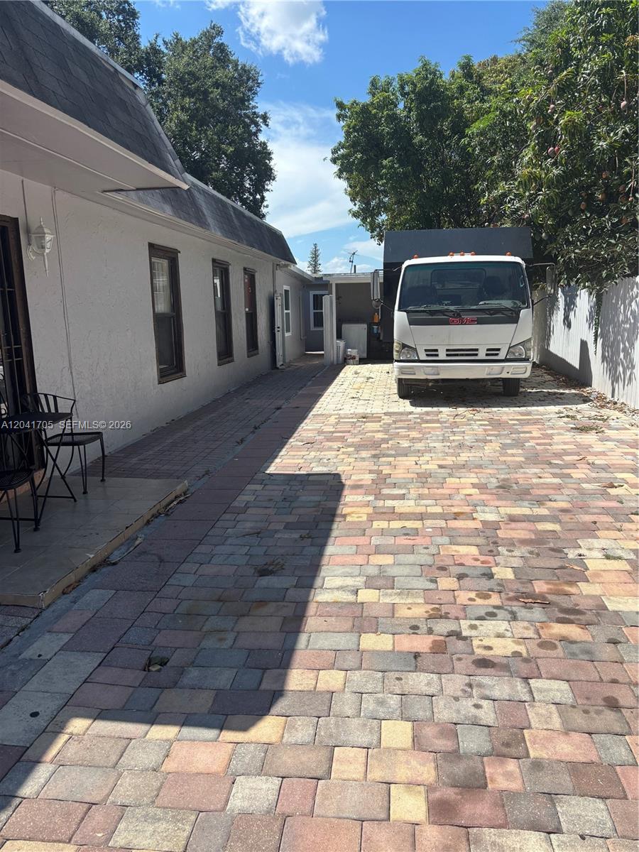 A white GMC truck is parked on a paved driveway beside a residential building — 21122 NW 39th Ave, Miami Gardens FL 33055, MIAMI GARDENS, FL