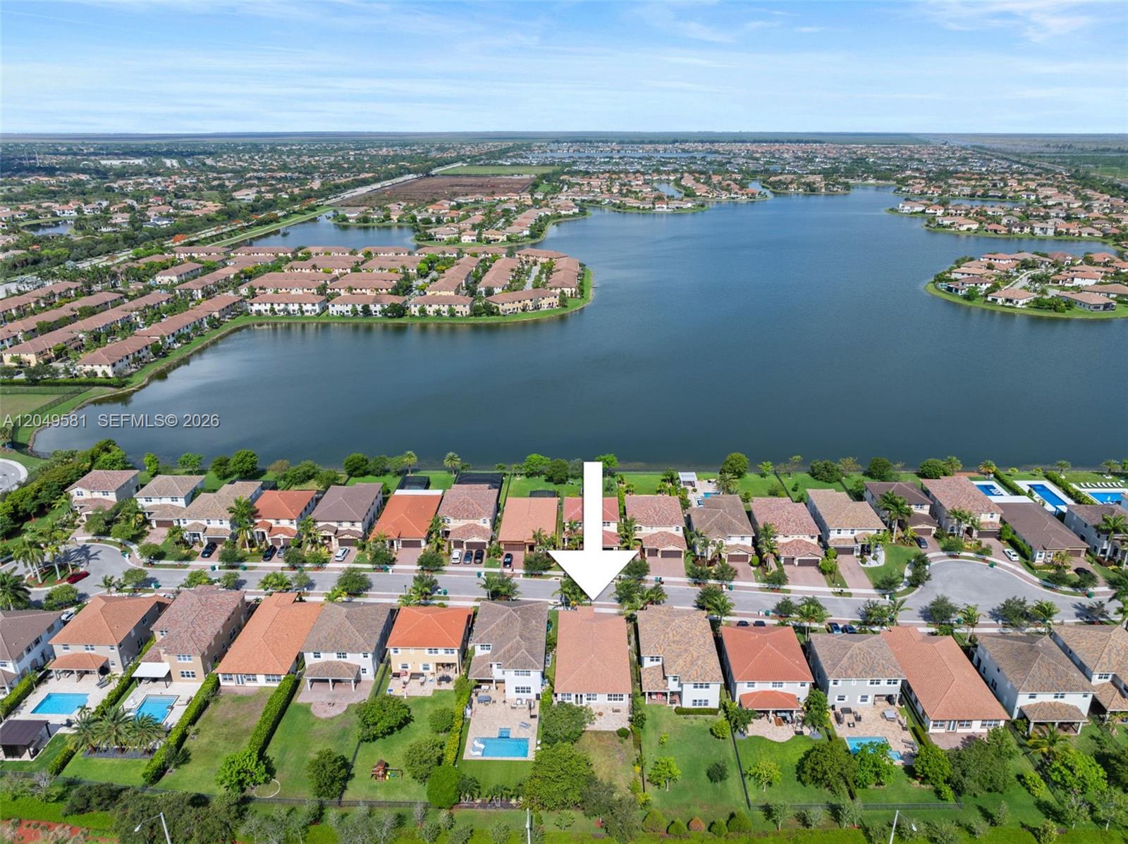 An aerial view shows a residential neighborhood with houses, a large lake, and a white arrow — 8530 Miralago Way, Parkland FL 33076, PARKLAND, FL