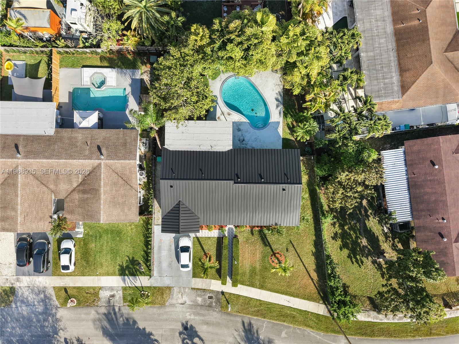 An aerial view shows a house with a dark metal roof, a pool, and a driveway — 16323 SW 103rd Pl, Miami FL 33157, MIAMI, FL