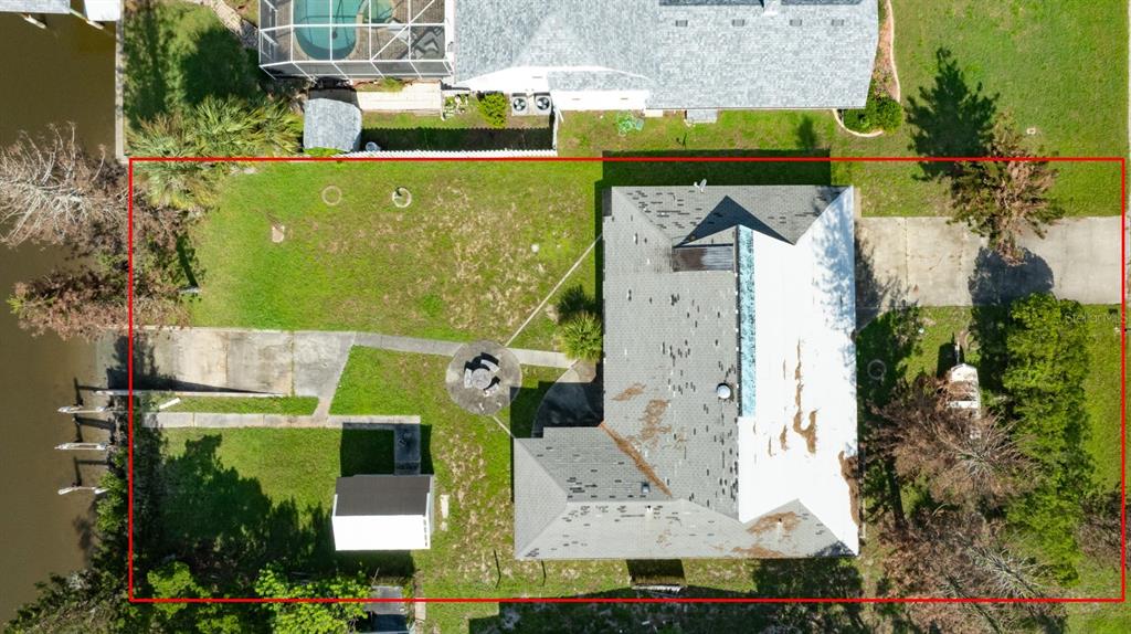 An aerial view shows a house with a large backyard, a driveway, and a boat dock — 21 CUNNINGHAM DRIVE, NEW SMYRNA BEACH, FL