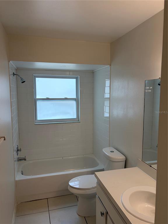 A bathroom featuring a white tiled bathtub shower combo, a toilet, and a vanity sink — 176 MARGIE STREET, PALM HARBOR, FL
