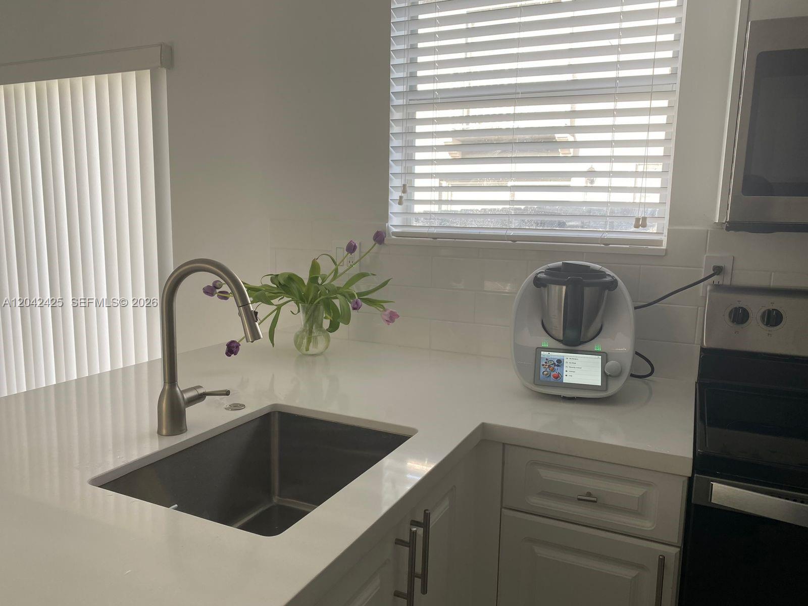 A kitchen features white countertops, a stainless steel sink, and a Thermomix appliance — 5245 NW 112th Ave # 8, Doral FL 33178, DORAL, FL