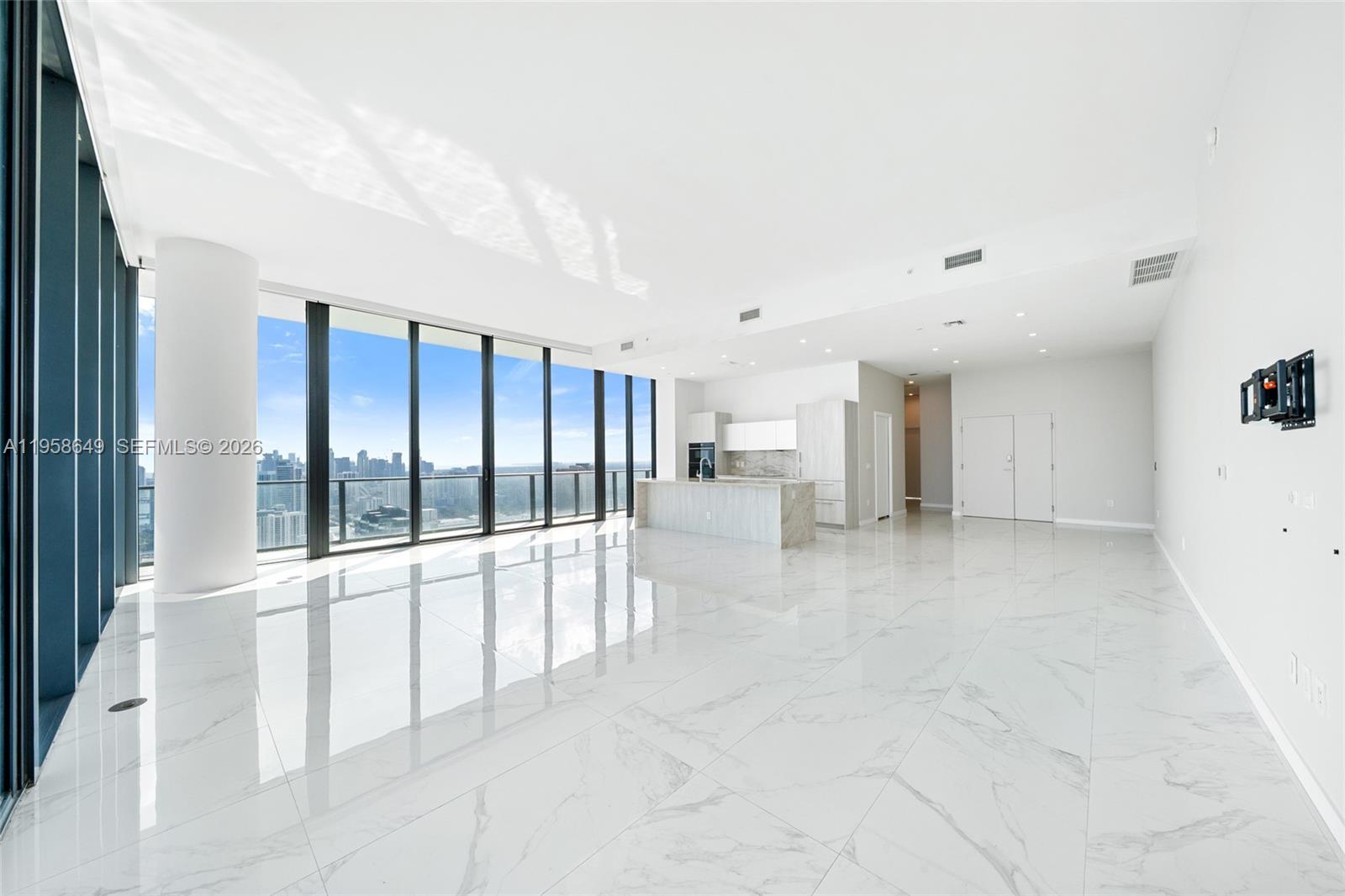 A bright, open-concept living area features white marble floors, floor-to-ceiling windows, and a kitchen — 480 NE 31st St, Miami FL 33137, MIAMI, FL
