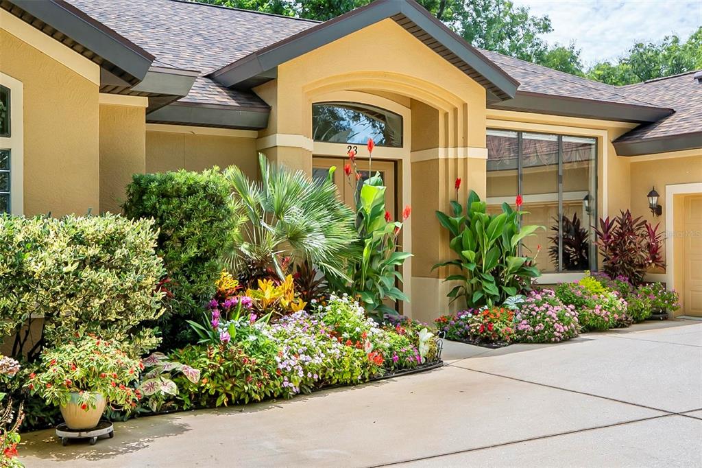 The exterior of a house features a landscaped garden bed in front of the entrance — 23 CREEKSIDE DRIVE, PALM COAST, FL