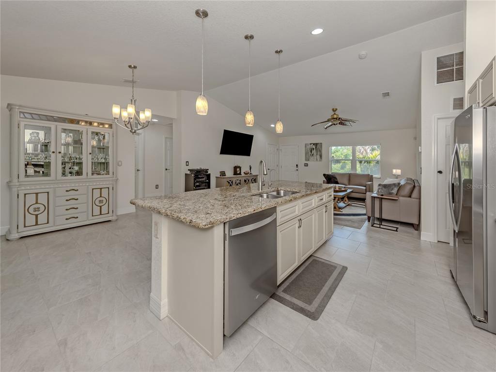 A kitchen with a granite island, stainless steel appliances, and an adjacent dining area — 3453 DRYDEN STREET, NORTH PORT, FL