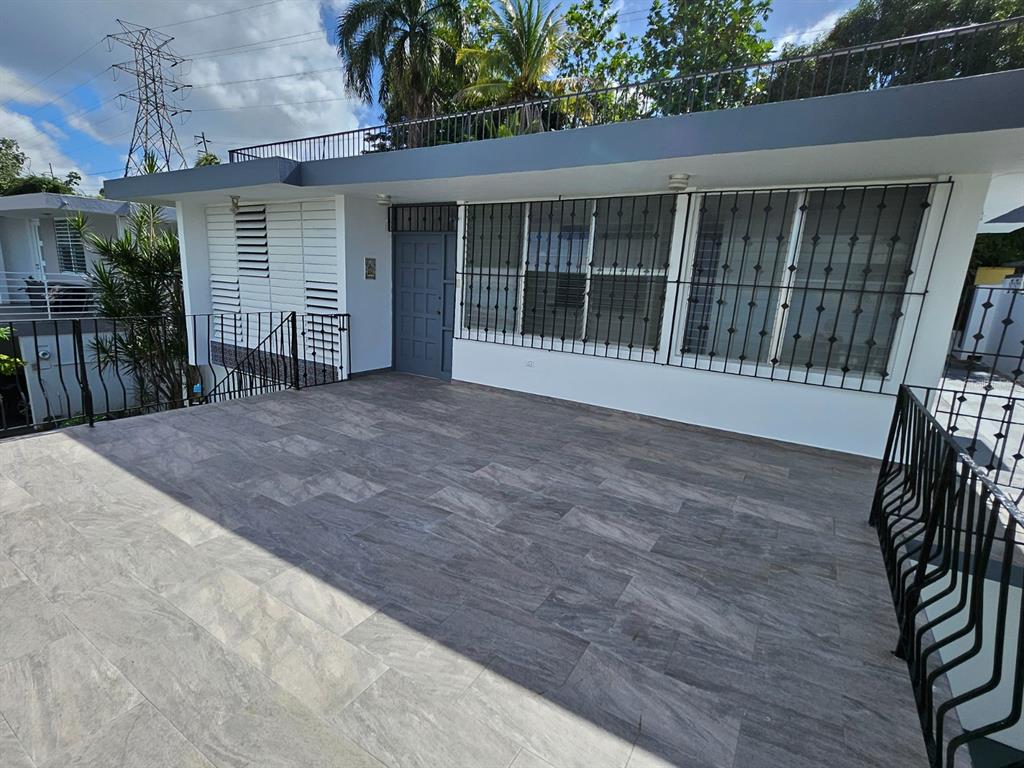 A spacious outdoor terrace with gray wood-look tile flooring features a white house exterior — 2085 Hercules st URB ALTO APOLO, GUAYNABO, PR