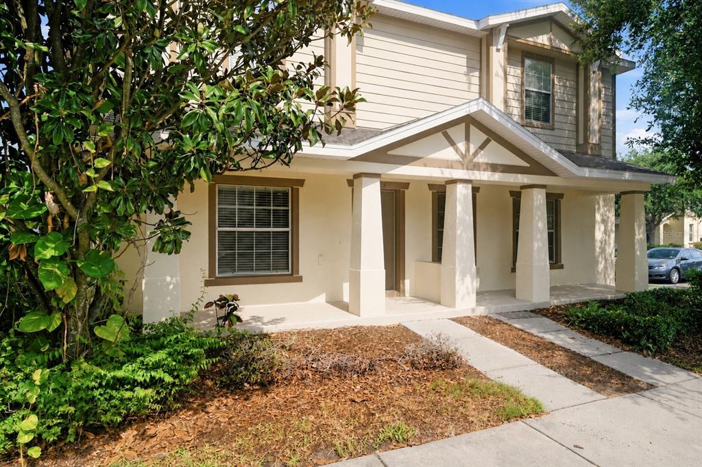 A two-story house with a beige stucco exterior, a covered front porch, and white columns — 4715 CHATTERTON WAY, RIVERVIEW, FL