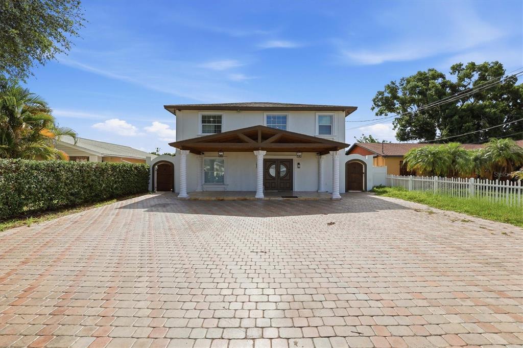 A two-story house with a paved driveway and a covered front porch with columns — 6611 N HALE AVENUE, TAMPA, FL