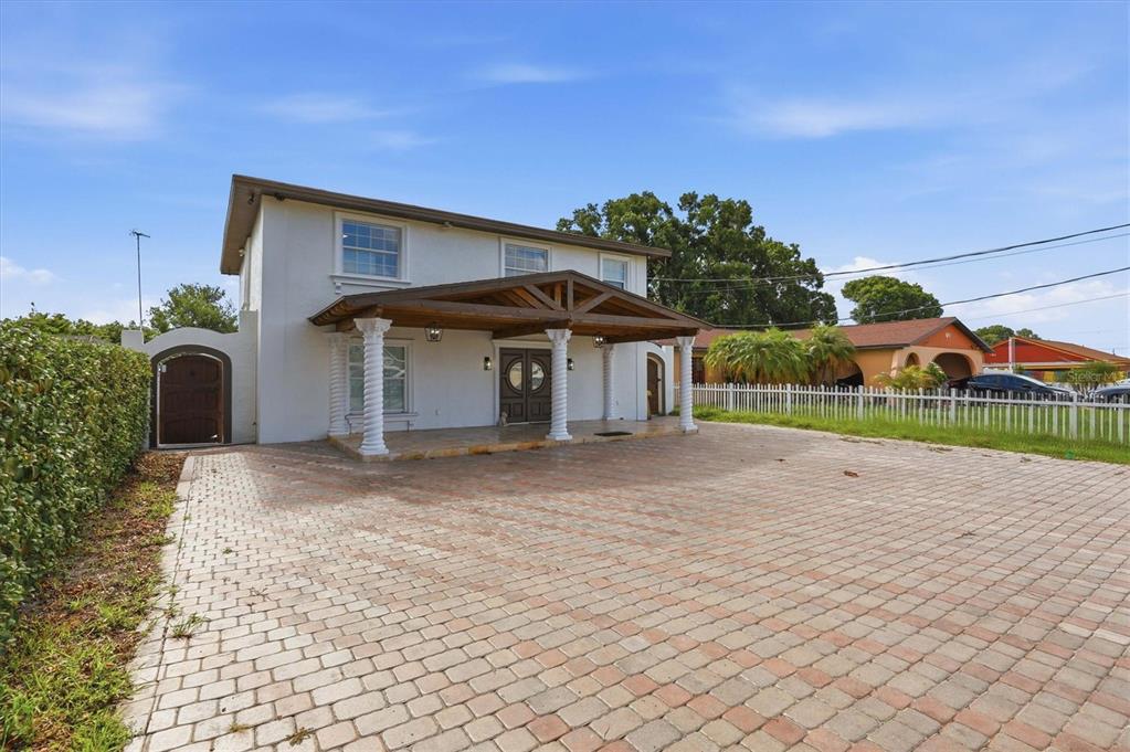 A two-story house with a paved driveway, a covered front porch, and white columns — 6611 N HALE AVENUE, TAMPA, FL