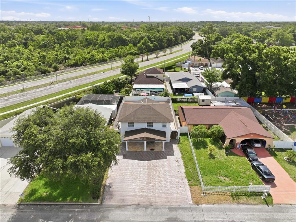 An aerial view shows a two-story house with a paved driveway and adjacent properties — 6611 N HALE AVENUE, TAMPA, FL