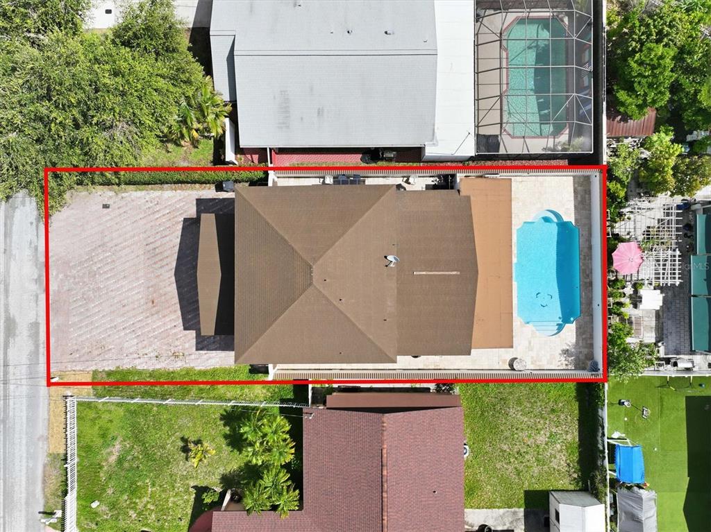 An aerial view shows a house with a brown roof, a paved driveway, and a pool — 6611 N HALE AVENUE, TAMPA, FL