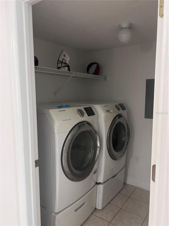 A laundry closet contains a white Samsung washer and dryer set beneath a wire shelf — 1064 PARK RIDGE CIRCLE, KISSIMMEE, FL