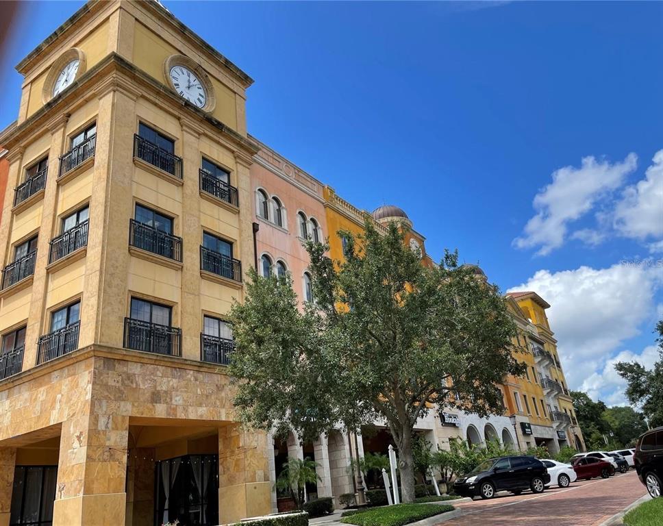 A multi-story building with a clock tower, balconies, and a stone-clad ground floor exterior — 2295 S HIAWASSEE ROAD UNIT 301, 302, ORLANDO, FL