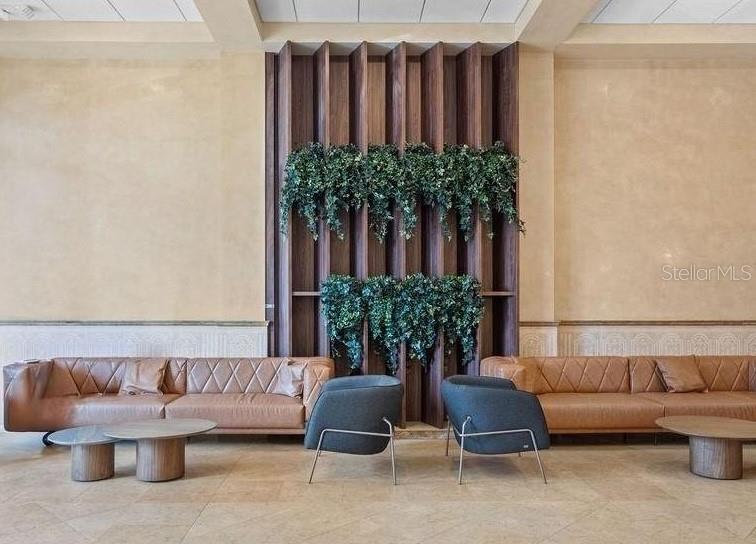A lobby features two tan leather sofas, two gray armchairs, and a vertical wood slat wall — 2295 S HIAWASSEE ROAD UNIT 301, 302, ORLANDO, FL