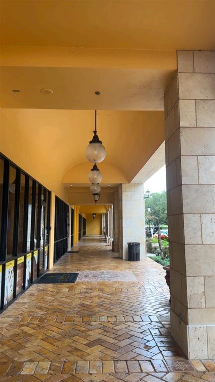 A covered outdoor walkway features stone tile flooring, arched ceilings, and hanging globe light fixtures — 2295 S HIAWASSEE ROAD UNIT 301, 302, ORLANDO, FL