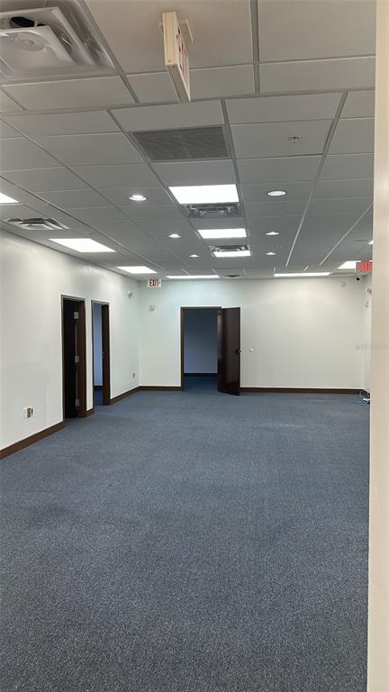 An empty office space with blue carpeting, white walls, and a drop ceiling with lights — 2295 S HIAWASSEE ROAD UNIT 301, 302, ORLANDO, FL