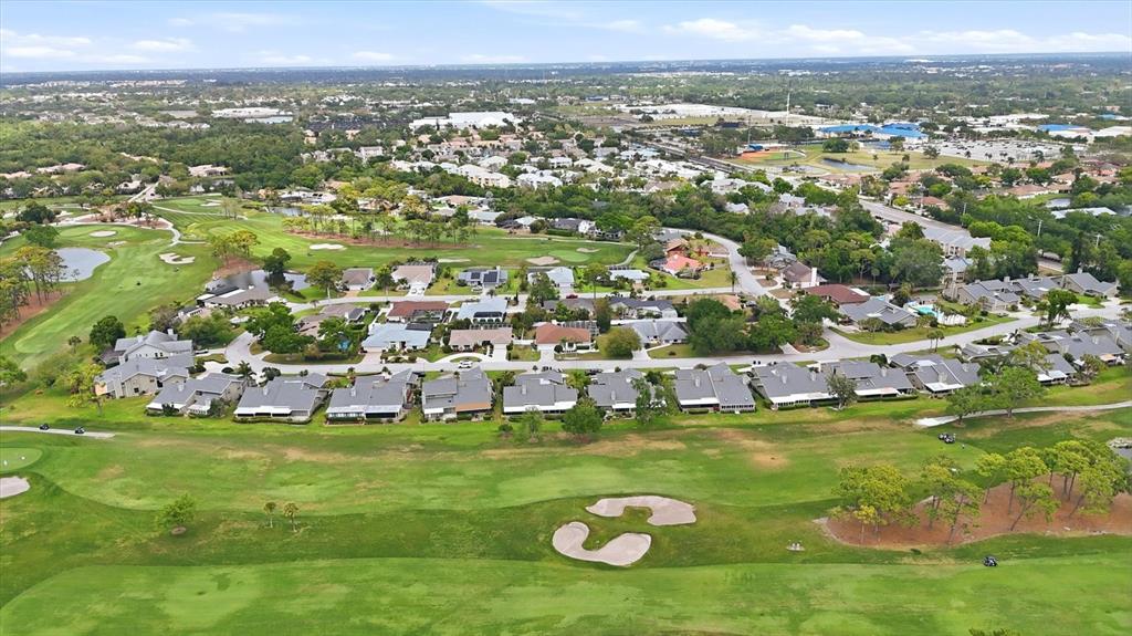 An aerial view of a residential neighborhood bordering a golf course with a sand bunker — 3508 AVENIDA MADERA, BRADENTON, FL