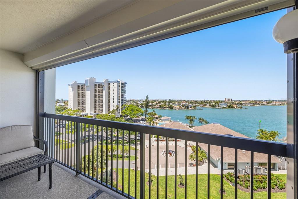 A balcony with a railing overlooks a body of water and nearby residential buildings — 9425 BLIND PASS ROAD UNIT 705, ST PETE BEACH, FL