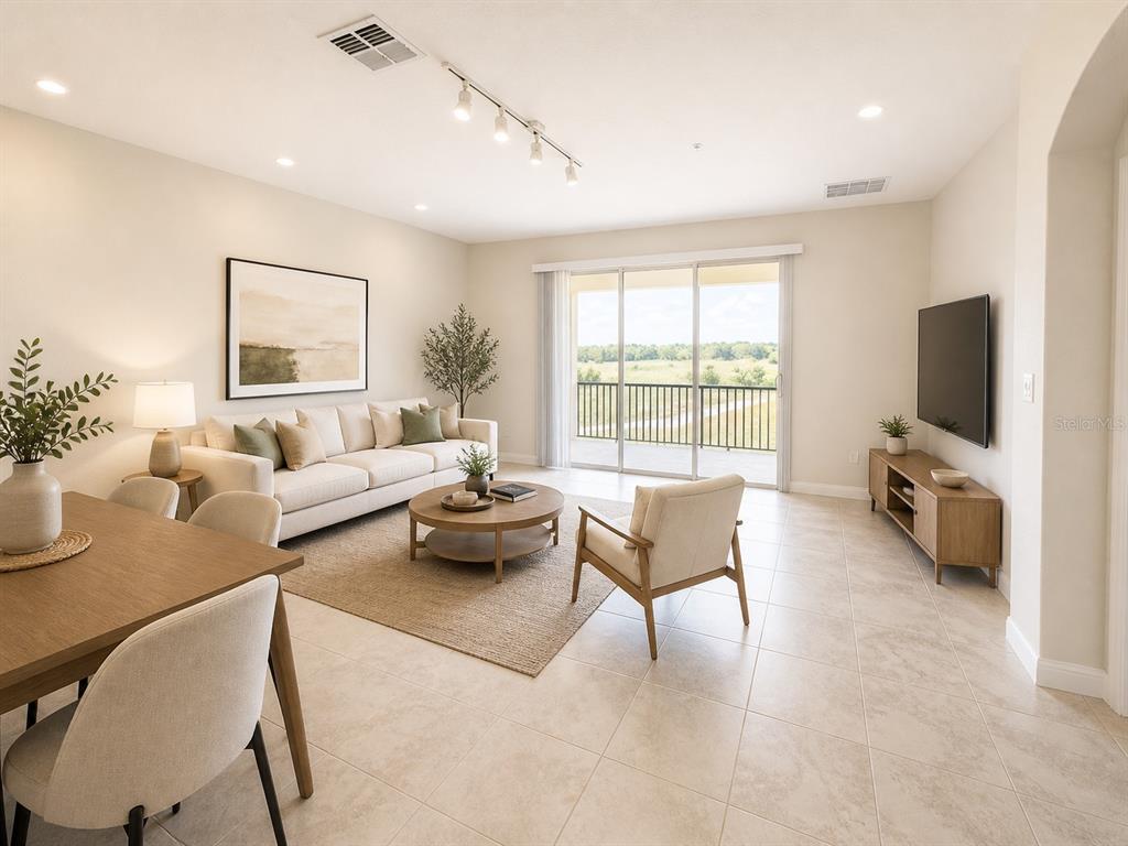 A bright living room features tile floors, a neutral sofa, and a sliding glass door — 505 OCEAN COURSE AVENUE UNIT 505, DAVENPORT, FL
