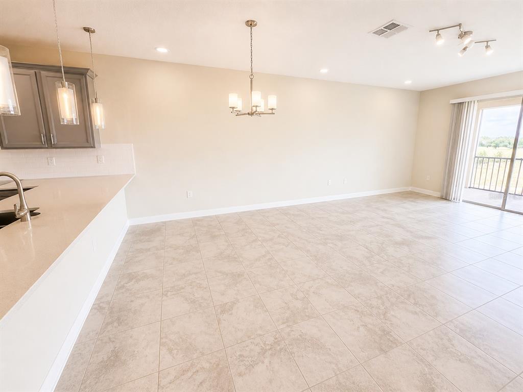 A kitchen with gray cabinets and a dining area featuring tile floors and a chandelier — 505 OCEAN COURSE AVENUE UNIT 505, DAVENPORT, FL