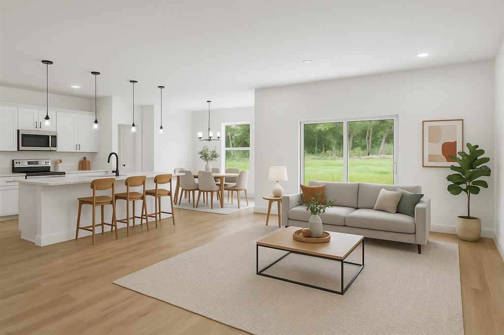 This digital rendering shows an open-concept kitchen, dining area, and living room with light flooring — 16954 SW 39TH CIRCLE, OCALA, FL