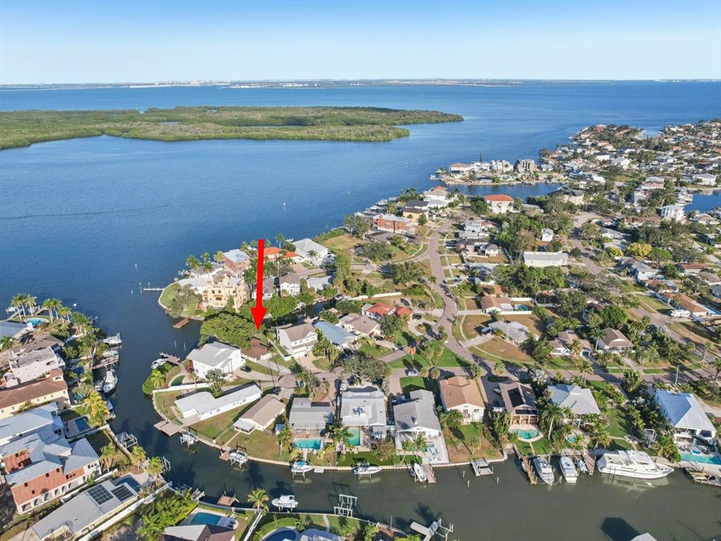 An aerial view shows a waterfront residential neighborhood with a red arrow pointing to a house — 1739 BAYOU GRANDE BOULEVARD NE, ST PETERSBURG, FL