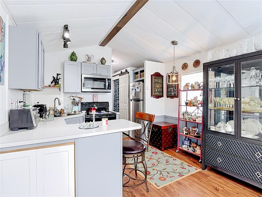 A kitchen features light gray cabinets, a breakfast bar, and a black display cabinet — 9000 US HWY 192 UNIT 297, CLERMONT, FL