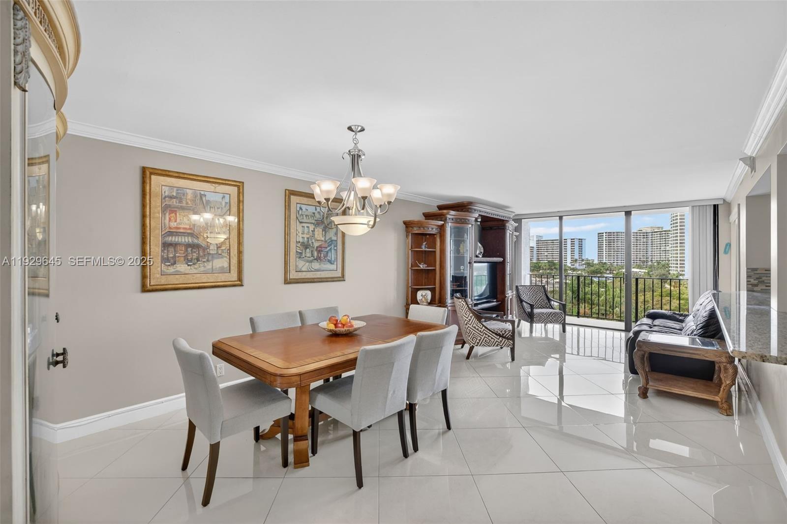 A dining area with a wooden table, light gray chairs, and tile flooring overlooks a balcony — 200 Leslie Dr # 707, Hallandale Beach FL 33009, HALLANDALE BEACH, FL