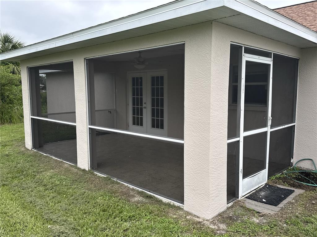 A screened-in patio with a tiled floor, white French doors, and a screen door — 2200 TOPSY TERRACE, NORTH PORT, FL