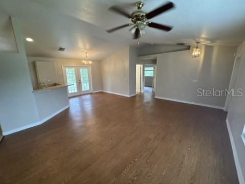 An open-concept living area features wood-look flooring, a ceiling fan, and a kitchen breakfast bar — 2200 TOPSY TERRACE, NORTH PORT, FL