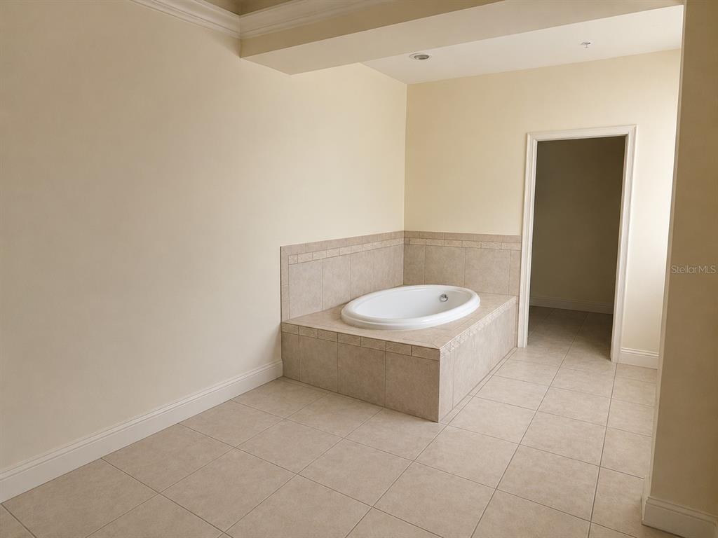 A bathroom features a tiled soaking tub deck and beige floor tiles — 3008 BELLA VISTA DRIVE, DAVENPORT, FL