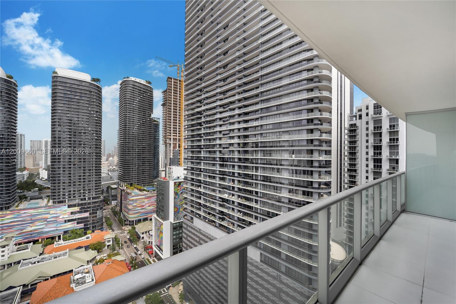 A high-rise balcony overlooks a dense urban cityscape with multiple modern skyscrapers — 1100 Miami Ave # 2808, Miami FL 33130, MIAMI, FL
