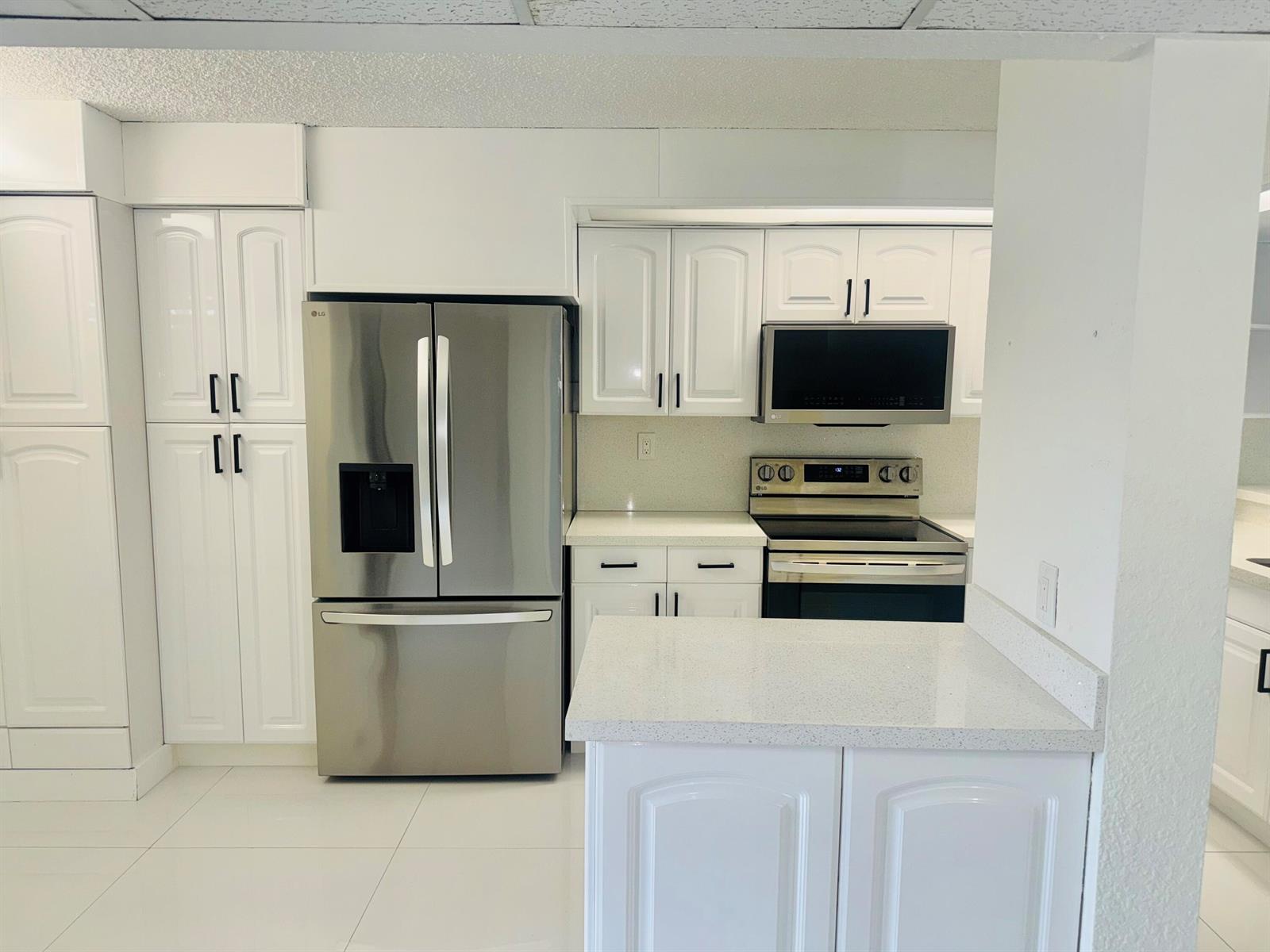 A kitchen featuring white cabinetry, stainless steel appliances, and light-colored countertops — 9 Royal Palm Way # 102, Boca Raton FL 33432, BOCA RATON, FL