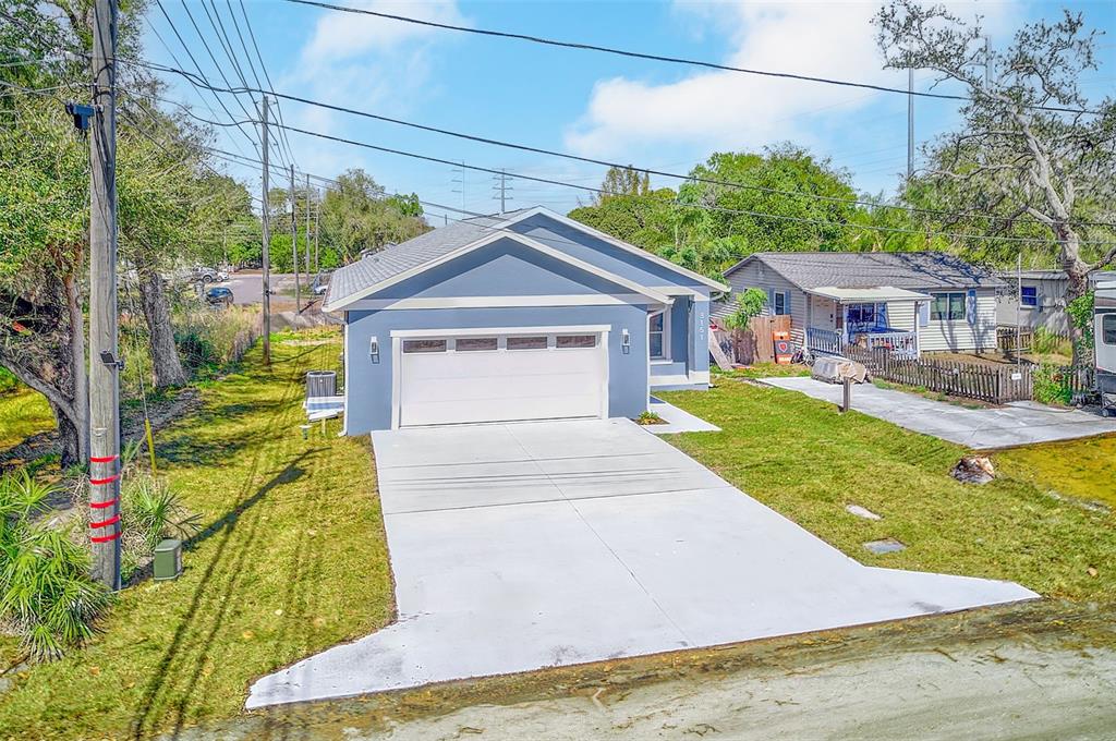 A blue single-story house with a white garage door and a concrete driveway — 3151 69TH AVENUE N, ST PETERSBURG, FL