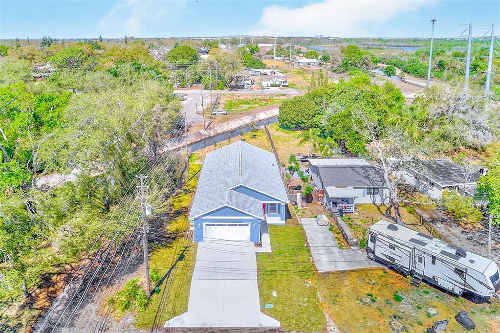 An aerial view shows a blue house with a concrete driveway and a parked RV nearby — 3151 69TH AVENUE N, ST PETERSBURG, FL