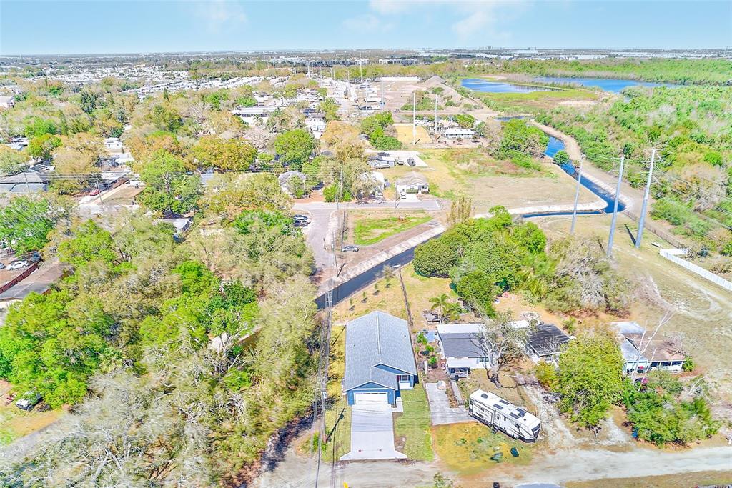 An aerial view shows a house with a blue roof, a driveway, and nearby trees — 3151 69TH AVENUE N, ST PETERSBURG, FL