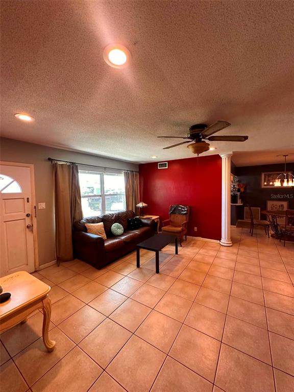 A living room features tile flooring, a red accent wall, and a brown leather sofa — 8923 110TH LANE, SEMINOLE, FL