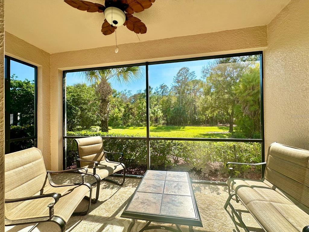 A screened-in patio features outdoor furniture, a ceiling fan, and a view of trees — 10726 CETRELLA DRIVE, FORT MYERS, FL