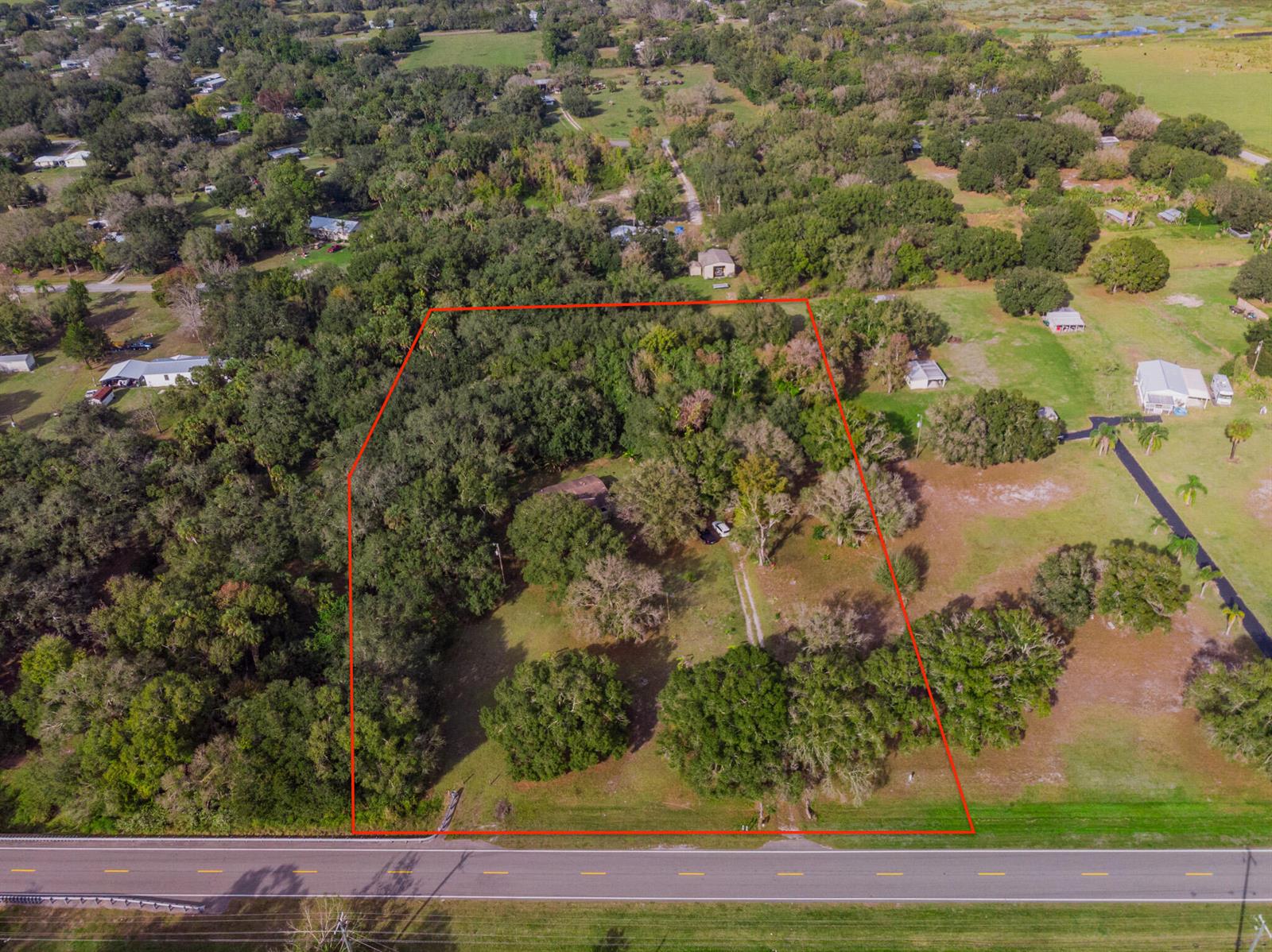 An aerial view shows a rectangular property lot outlined in red bordering a paved road — 3453 NW 160th Street, Okeechobee FL 34972, OKEECHOBEE, FL