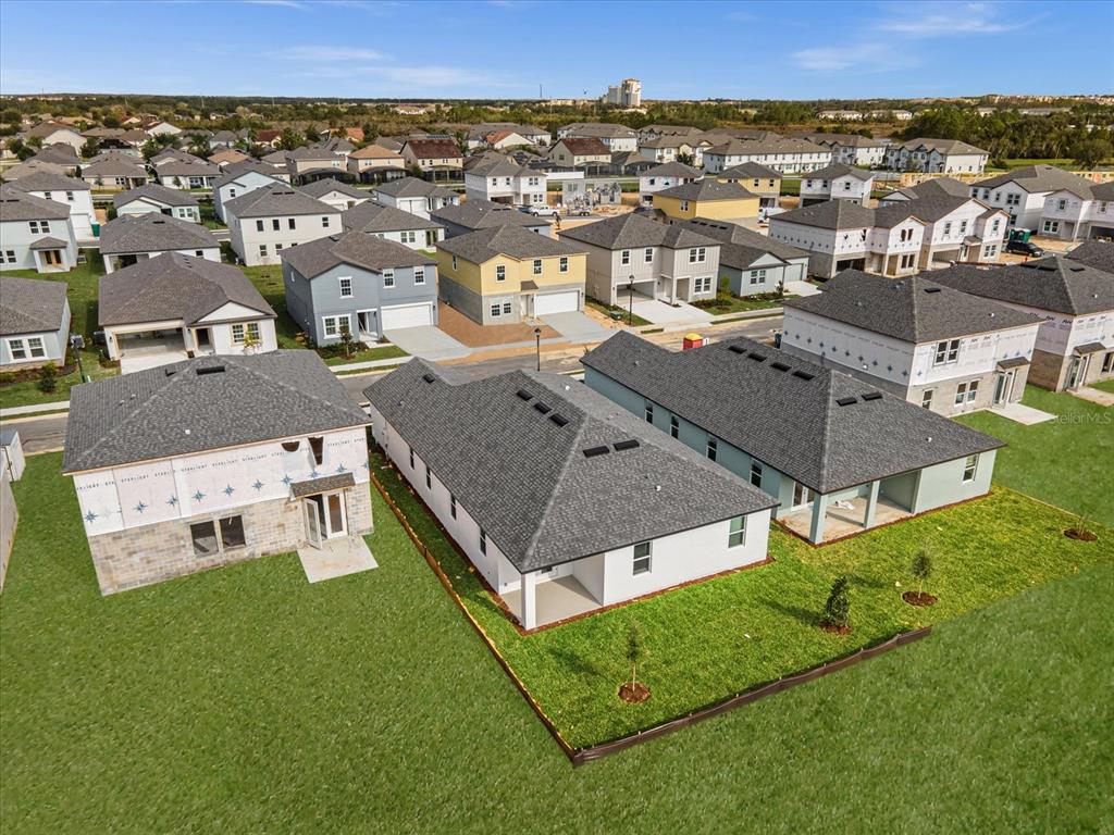 An aerial view shows several newly constructed suburban houses with gray roofs and green lawns — 2355 LANCASHIRE STREET, DAVENPORT, FL