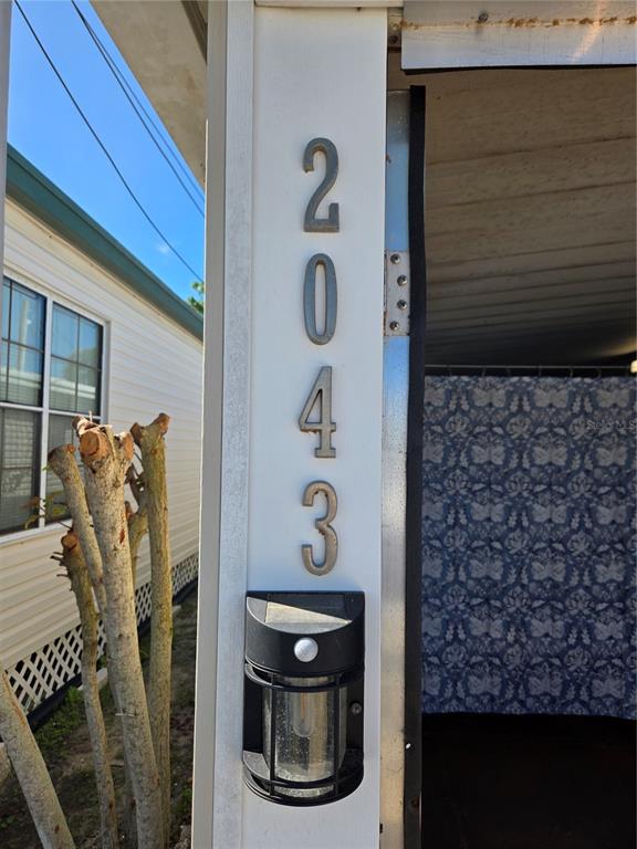 The house number 2043 is mounted vertically on a white post next to a solar light — 2043 KETCH CIRCLE UNIT C7, PALM HARBOR, FL