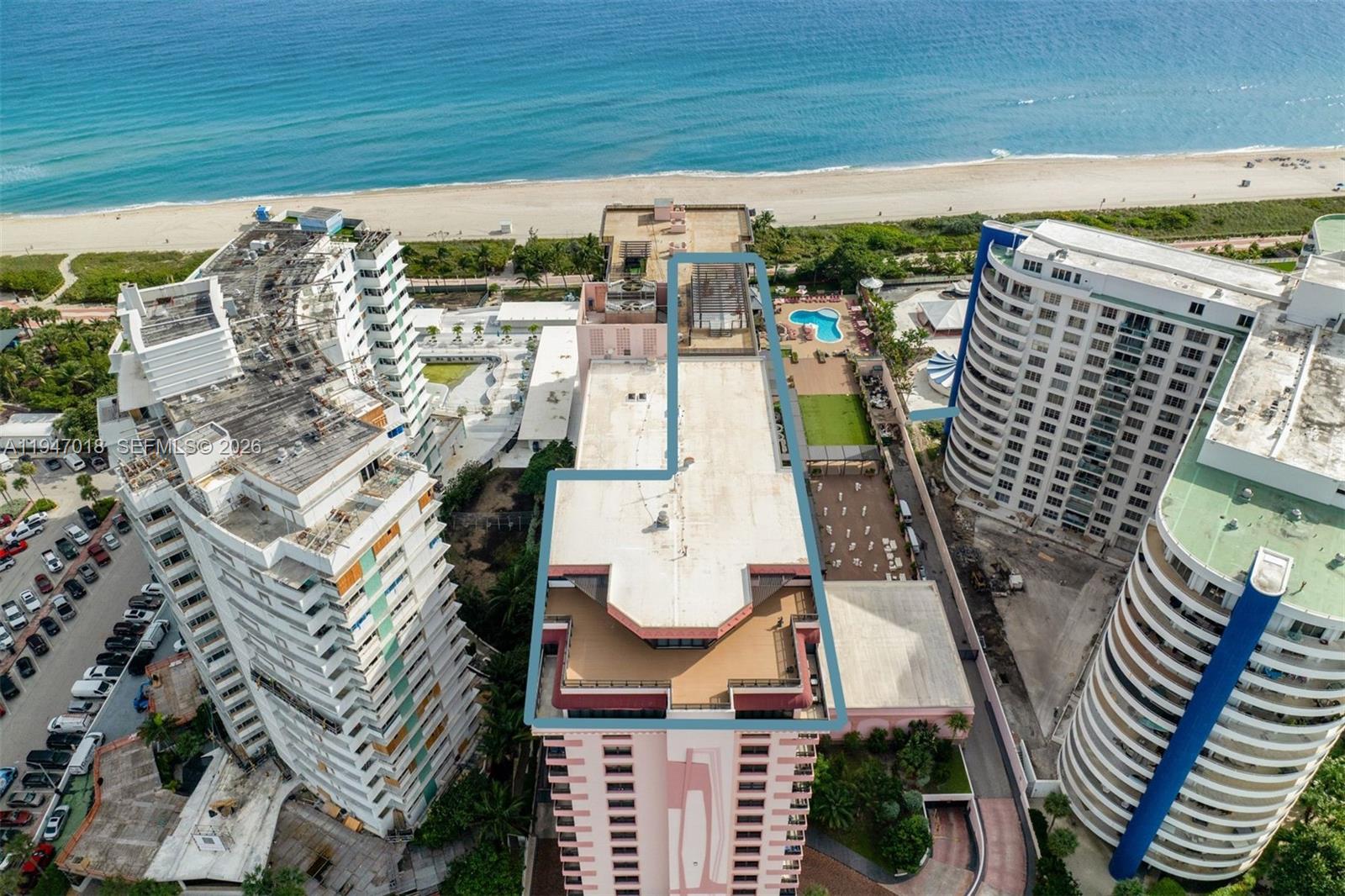 An aerial view shows a pink high-rise building with a blue outline on its roof — 5225 Collins Ave, Miami Beach FL 33140, MIAMI BEACH, FL